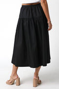 Black tiered skirt worn by a person on a white background