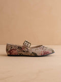 Floral patterned shoe with a buckle on a beige background