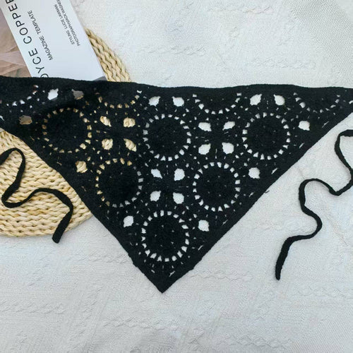 Black bandana with white patterns on a textured surface