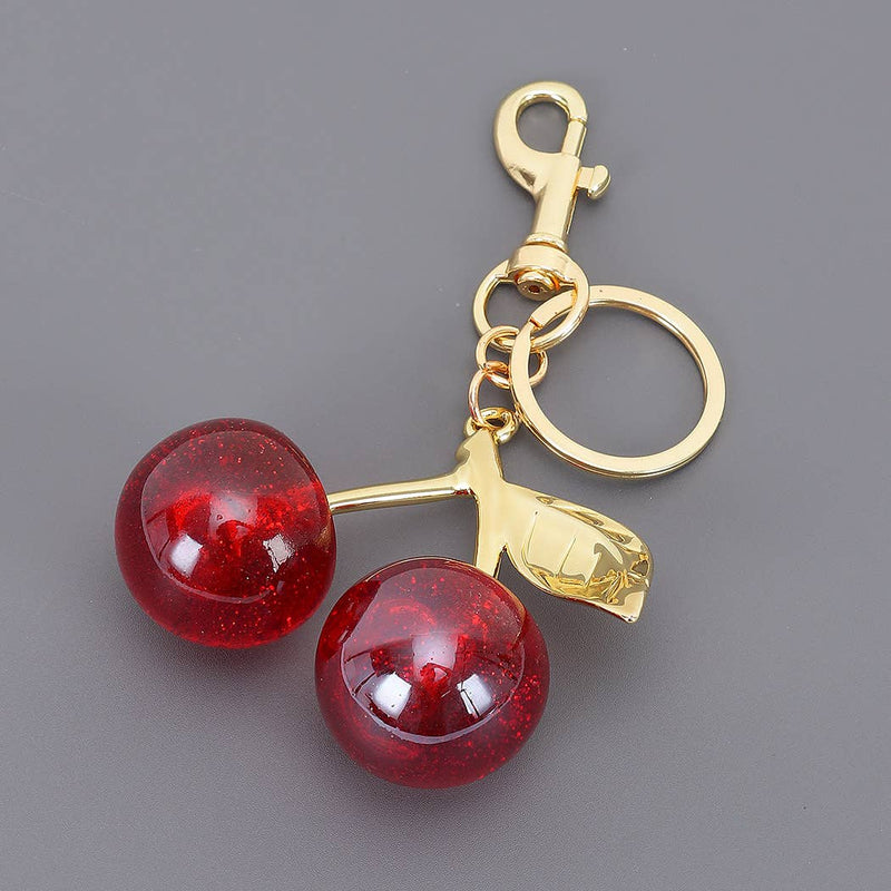 Keychain with red cherries and gold stem on a gray background