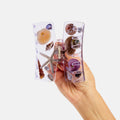 Hand holding a clear phone case with seashell designs on a white background