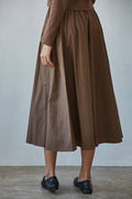 Brown dress worn by a person on a plain background