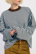 Person wearing a brown and blue striped sweater with a plain background