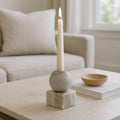 Candle in a decorative holder on a coffee table with a blurred background