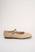 A single beige leather Mary Jane flat shoe with a small silver buckle, shown in profile against a plain light gray background.