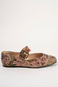 A single women's flat shoe with a textured, woven floral pattern in muted pink, green, and brown tones, featuring a decorative buckle strap across the top, shown against a plain white background.
