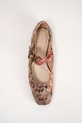 A single ballet flat shoe from the brand Odissea, featuring a textured snakeskin pattern in earthy tones of brown, beige, and muted red, with a matching fabric bow on the instep.