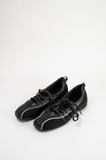 A pair of black leather low-top sneakers with white piping details and black laces, displayed on a clean white background.