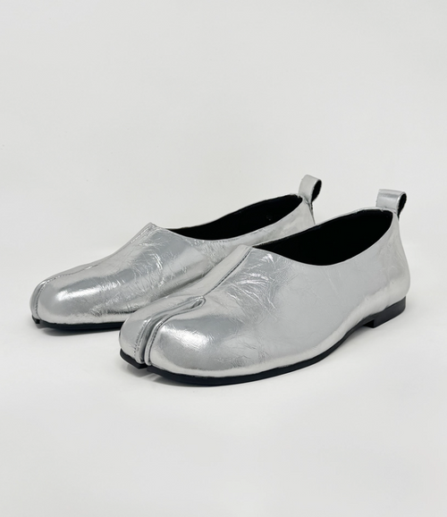 Pair of silver metallic loafers on a light gray background