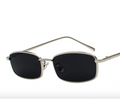 Sunglasses with silver frame and black lenses on a white background