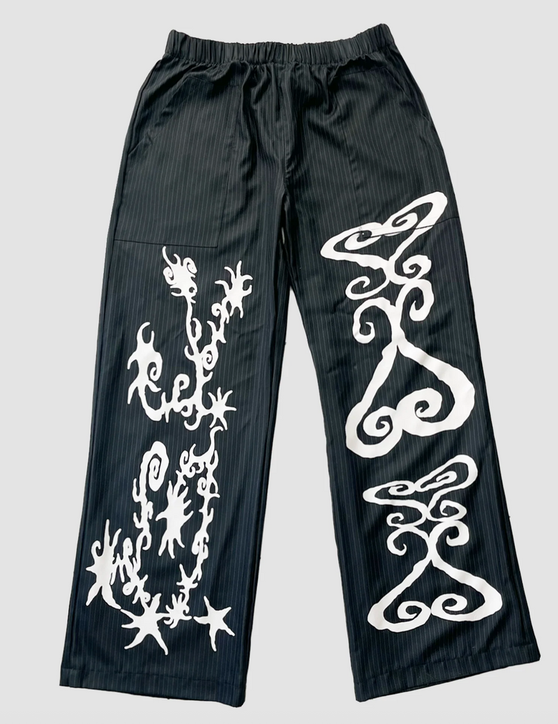 Black pants with white tribal patterns on a light gray background