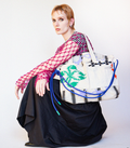 Person holding a large tote bag with colorful design on a white background