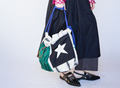 Person holding a colorful tote bag with a star design on a white background