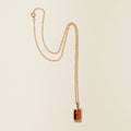 amber and gold charm necklace on white background