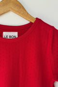Red t-shirt with 'LE BON' label on a wooden hanger against a white background