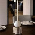 Candle holder with a candle on a table setting in a room.