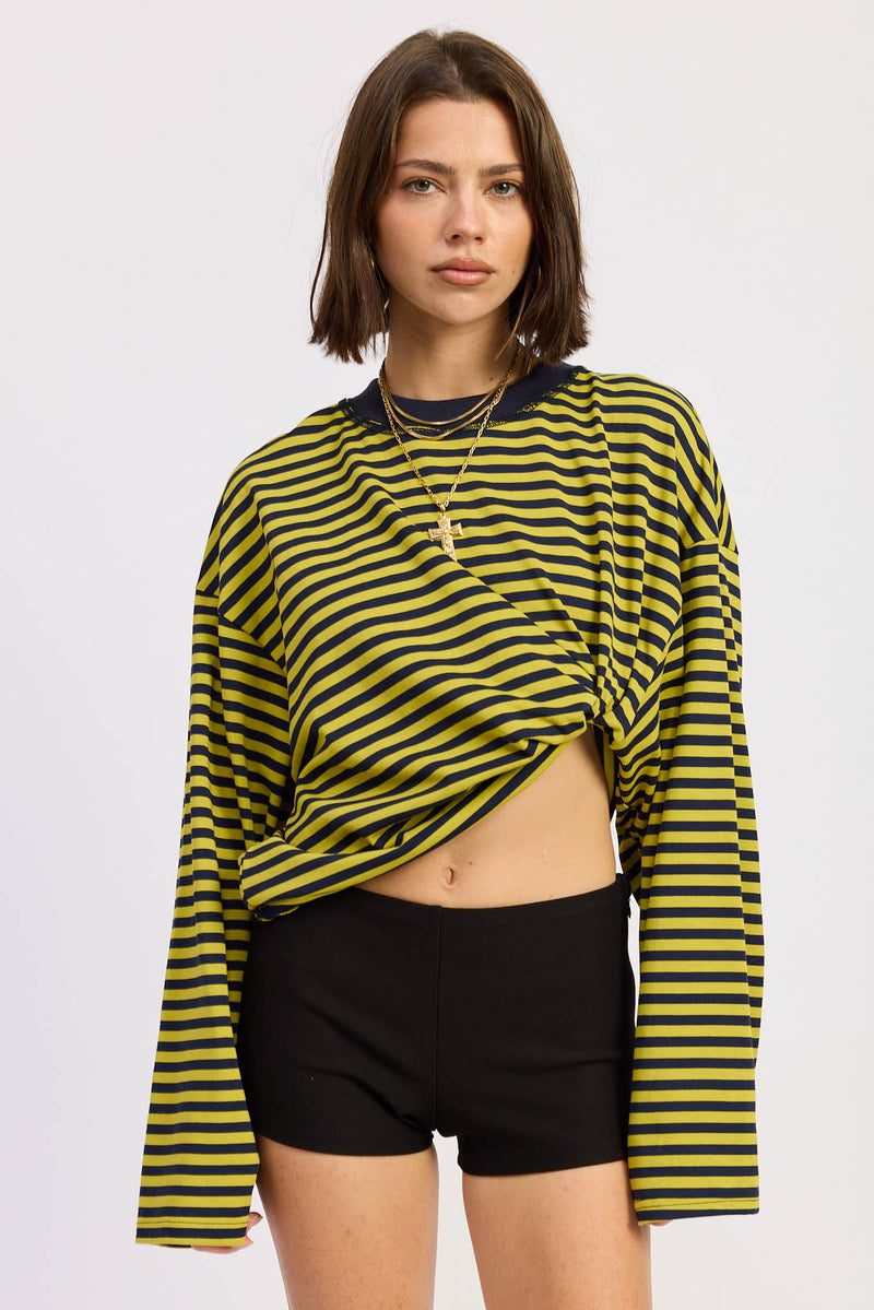 Woman wearing a yellow and black striped long-sleeve top and black shorts on a white background
