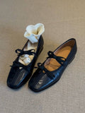 Black shoes with laces on a textured beige surface