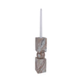 Marble-patterned candle holder with a white candle on a white background