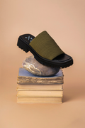 Green sandal on a stack of books with a beige background