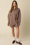 Woman wearing a brown and beige striped outfit on a beige background