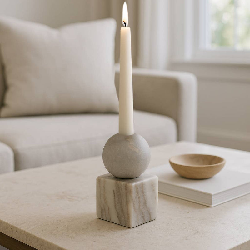 Candle holder with a candle on a coffee table in a living room setting