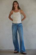 Woman wearing white thin strap top and jeans