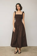 Woman wearing a brown dress with a plain background