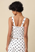 Woman wearing a polka dot dress with a beige background