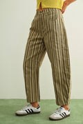 Person wearing striped pants and Adidas shoes on a green and beige background