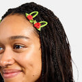 Person wearing a decorative headband with red roses and green leaves on a plain background