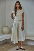 Woman wearing a white outfit against a plain background