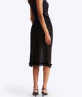 Black dress with ruffled hem on a white background