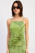 Woman wearing a green tank top with a subtle pattern on a white background