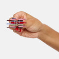 Hand holding a transparent fidget spinner with colorful ends on a white background