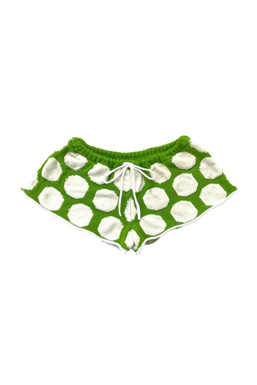 Green shorts with white polka dots on a white background