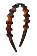 A translucent amber-brown tortoiseshell hair claw back headband on a solid white background.